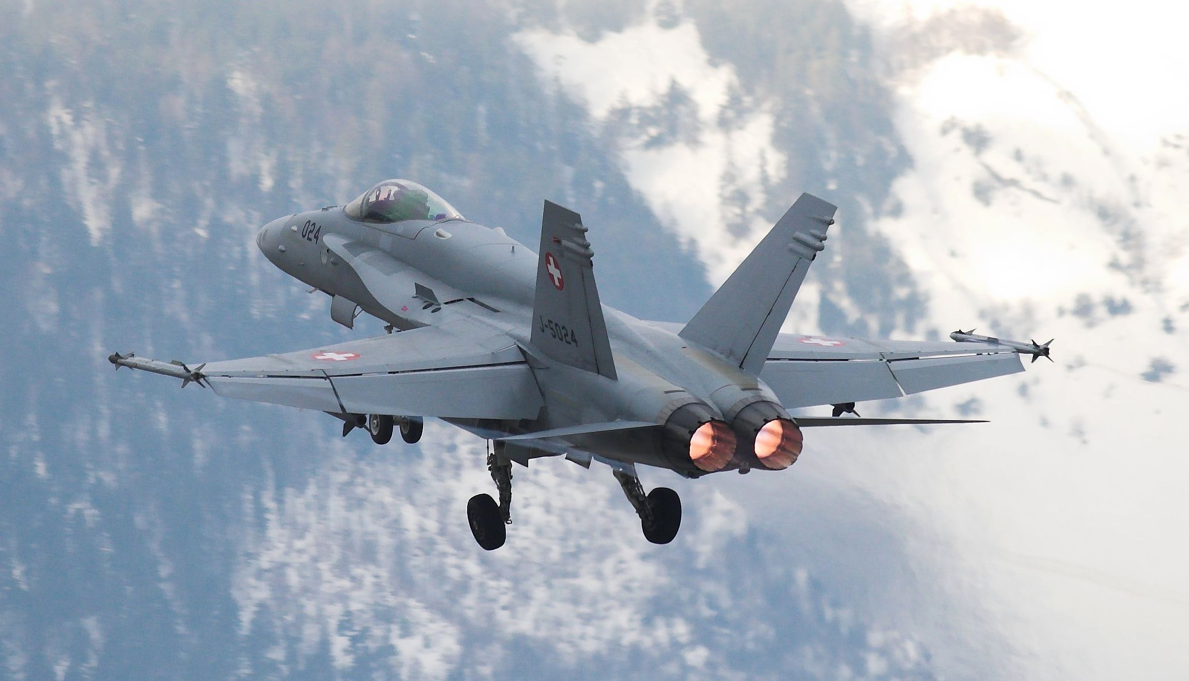 F-18 al decollo con le Alpi innevate che fanno da sfondo. F-18C al decollo